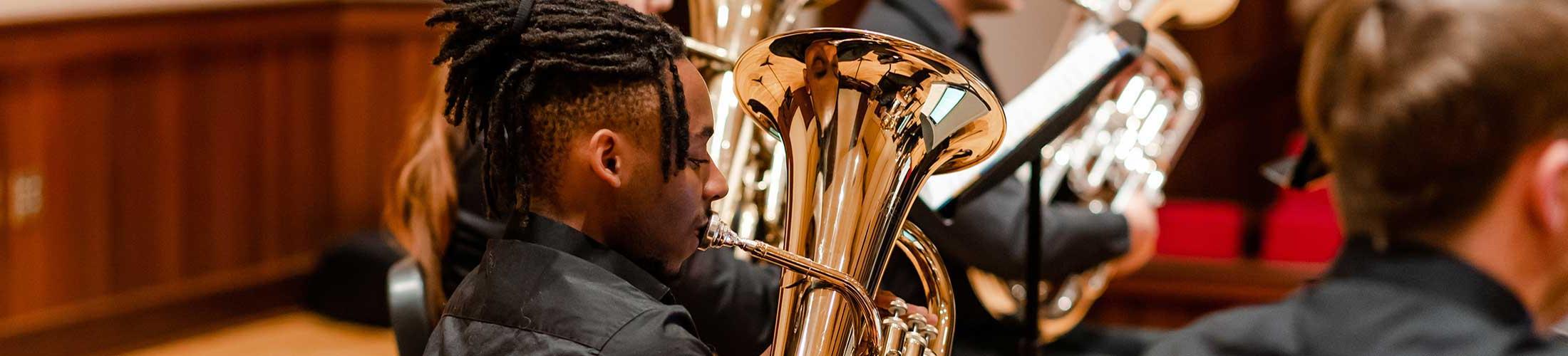 Student playing brass instrument.